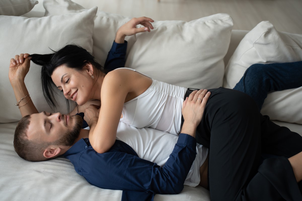 intimate couple lounging on a sofa, sharing a serene and tender moment together